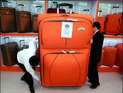 staff-members-try-to-move-huge-trolley-case-during-chinese-export-commodities-fair-in-guangzhou